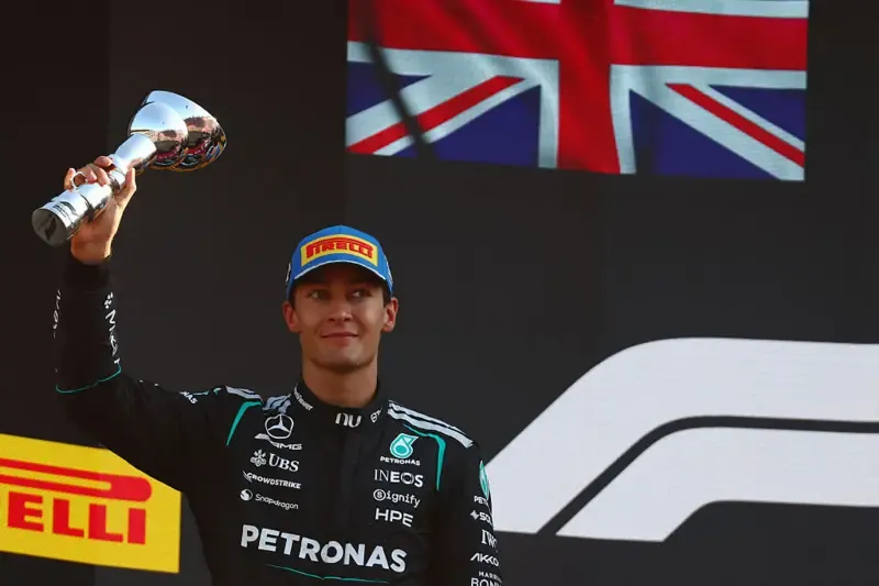 George Russell lifts his P2 trophy on the podium at the Italian Grand Prix